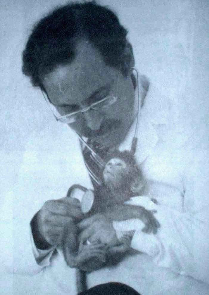 Joel Wallach holds infant rhesus monkey with cystic fibrosis